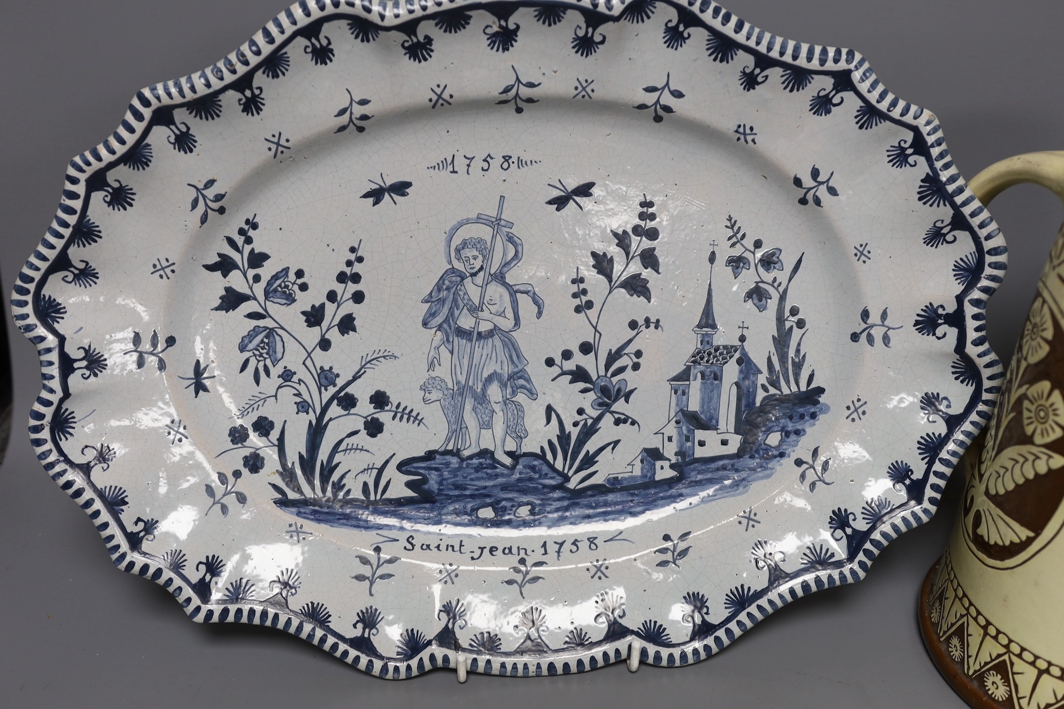 A Brannum sgraffito jug dated 1881 and a French faience serving dish, 42cm
